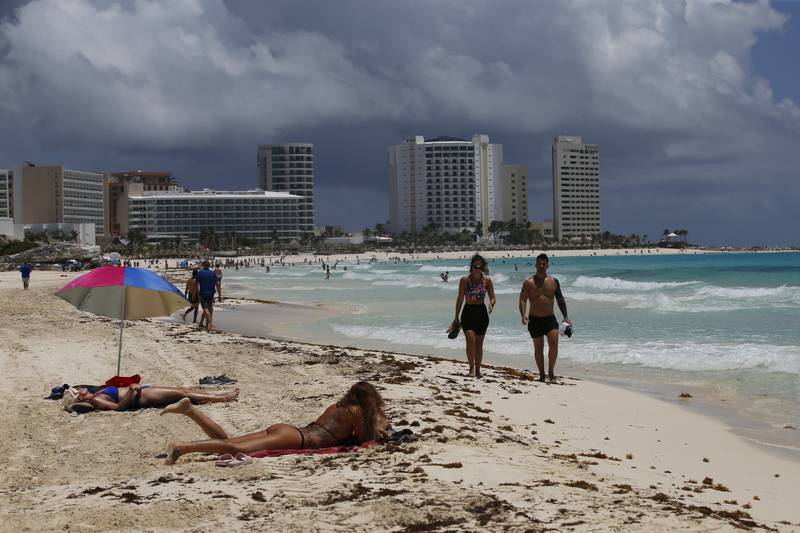 Turistas toman el sol en la playa antes de la llegada del huracán Grace, en Cancún, en el estado de Quintana Roo, México. (AP)