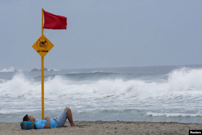 Un hombre descansa en una playa mientras el huracán Agatha avanzaba hacia la costa sur de México, en Puerto Escondido, en el estado de Oaxaca, México, el 29 de mayo de 2022.